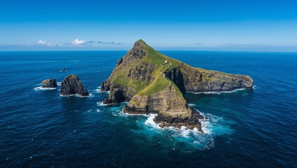 Small rocky island rising from turquoise ocean waters under bright blue sky