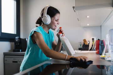 Girl enjoying housework with headphones on
