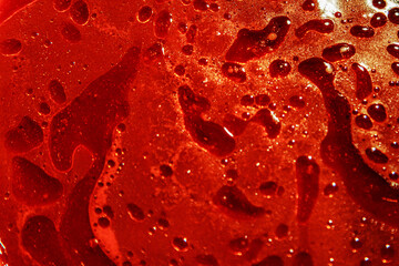 Close-up of vibrant red liquid with oil texture