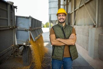 Truck unloading corn at collection point with worker