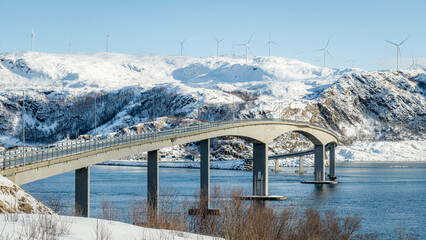 Winter bridge stretching across snowy Norwegian fjord, in Sommaroy