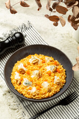 Vertical image of lunch with homemade Pumpkin Risotto with Gorgonzola Cheese and walnuts. Italian meal.