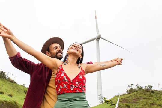 Couple embracing clean energy lifestyle with wind turbine