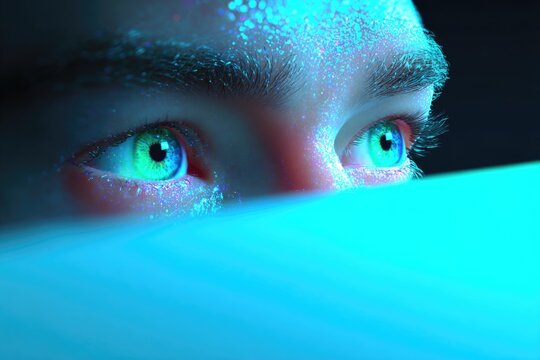 Intense gaze illuminated by vibrant blue light, showcasing capti