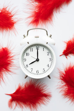Alarm clock with red feathers symbolizing menstruation