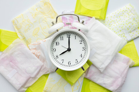 Clock and sanitary pads symbolizing menstruation cycle