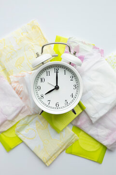 Alarm clock and sanitary pads symbolizing menstruation timing
