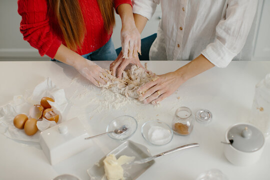 Family hands kneading christmas dough together in kitchen