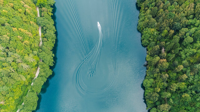 Aerial view of boat navigating Levico Lake in Italy