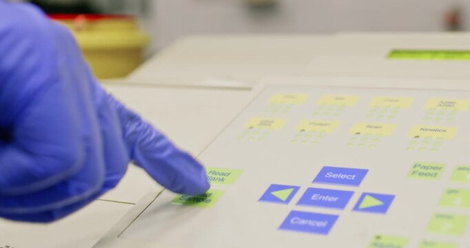 The scientist places a beak containing bacterial cells into a spectrophotometer and measures the concentration of bacterial cells after growth.