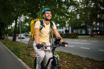 Fototapeta premium Food delivery courier riding bicycle in city