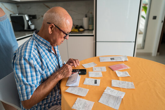 Elderly man managing household finances at home
