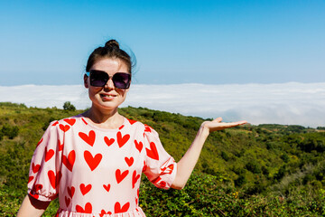Portrait of a mature girl in sunglasses in the mountains.