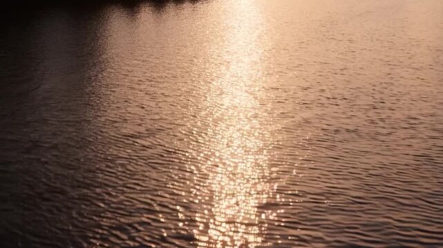 Sunbeam on water ripples view from above, evening sunset and beautiful sunlight on water
