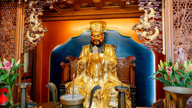 Ornate statue of deity with dragon carvings in temple