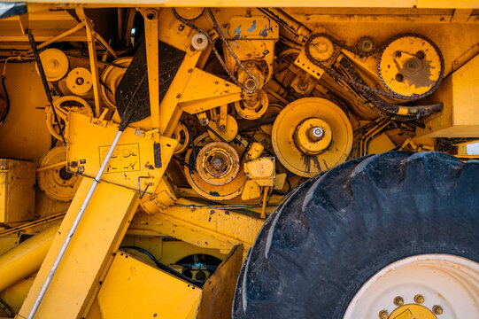 Close up view of machinery parts in a yellow tractor