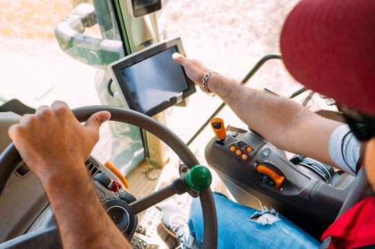 Farmer operating tractor with modern technology