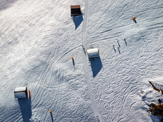 Wooden huts seen from above, in the Alps, on a sunny winter day