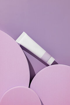 White cosmetic tube on purple podiums with purple backdrop