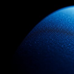 Close-up of a textured blue surface with a gradient, evoking depth and detail against a dark background.