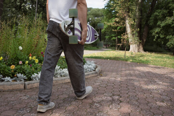 Man walking in park with vintage skateboard cruiser