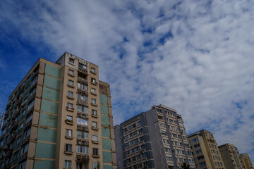 Naklejka premium A row of pastel apartment blocks under cloudy sky