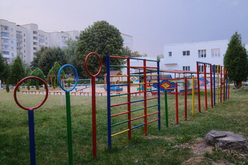 Fototapeta premium Outdoor play area with colorful equipment stands on the green grass.