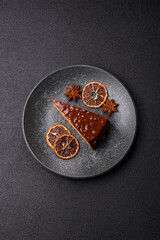 A slice of sweet layered cake covered in chocolate with nuts and caramel. A slice of chocolate cake