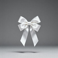 Elegant white satin ribbon bow isolated on a gray background, symbolizing celebration, gift wrapping, or decoration.