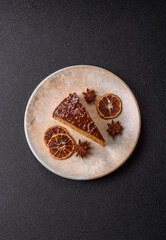 A slice of sweet layered cake covered in chocolate with nuts and caramel. A slice of chocolate cake