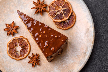 A slice of sweet layered cake covered in chocolate with nuts and caramel. A slice of chocolate cake