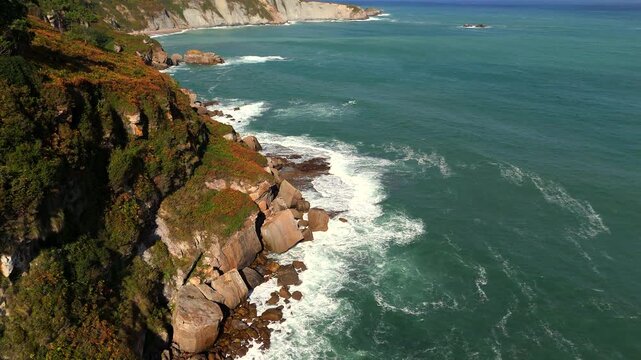 Aerial coastal cliffs with ocean waves and natural green landscape 