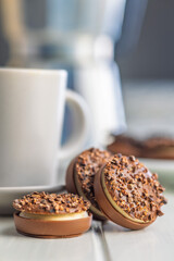 Sweet chocolate pralines. Chocolate candies and coffee cup on white table.