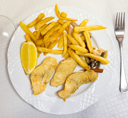 Delicious battered fish with french fries and lemon. Serving fresh Atlantic fish in a Spanish cafe
