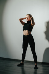 Obraz premium A young attractive woman is engaged in modern dance choreography in a ballet studio.