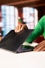 Teleworker at home ending job shift, closing laptop and leaving desk. Freelancer in apartment shutting down notebook device after finishing job tasks for the day, close up shot