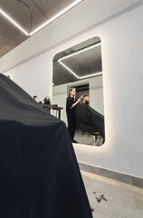 Woman Barber making customer Fashionable haircut in Modern style barbershop. Male hair cutting with scissors. Bearded Man client visit gentleman grooming beauty salon for hairstyle care