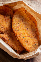 Southern fried chicken peices in a brown takeaway paper bag background backdrop. Recycling biodegradable food packaging.