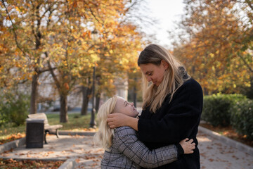 Obraz premium Mother daughter hugging, sharing a tender moment in a beautiful autumn park