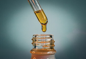 Dropper dispensing amber liquid into a glass bottle with a soft gradient background, symbolizing natural skincare, wellness, essential oils, and organic beauty products for self-care and rejuvenation