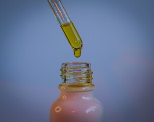 A close-up shot of a dropper dispensing yellow liquid into a white glass bottle, symbolizing natural beauty products, skincare essentials, and wellness, with soft gradient background and elegant light