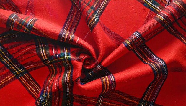 A close-up view of vibrant red tartan fabric, featuring intricate crisscrossing patterns in various shades of red, black, and gold.