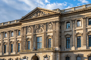 Exterior view of the Louvre Palace along the River Seine on Quai Francois Mitterrand, historic architecture in the heart of Paris, France.

