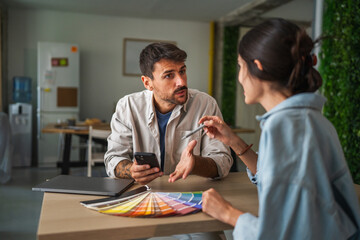 Designers collaborating on creative project discussing color palette indoors