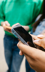 Vertical shot of young group of people using mobile phones, text message on cell app. Social media and technology lifestyle concept