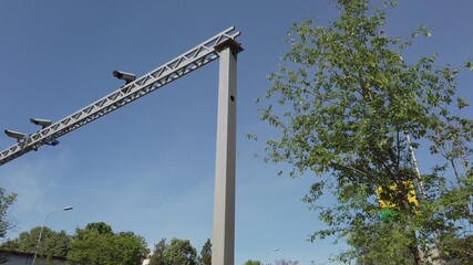Modern traffic monitoring structure with cameras under a clear blue sky in an urban environment