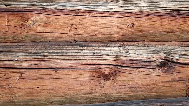 Close-up of fragment of facade of old log house, featuring natural wood textures, knots, weathered cracks. Rustic design, architecture. For creating warm, authentic organic atmosphere in projects