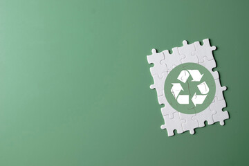 A recycle symbol on a completed jigsaw puzzle. A concept for environmental solutions, sustainability, conservation, and protecting the planet. An eco-friendly and green concept.