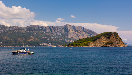 Boats and motorboats against the background of the island of St. Nicholas in the city of Budva, Montenegro