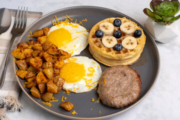 fried eggs along with waffles and home fries